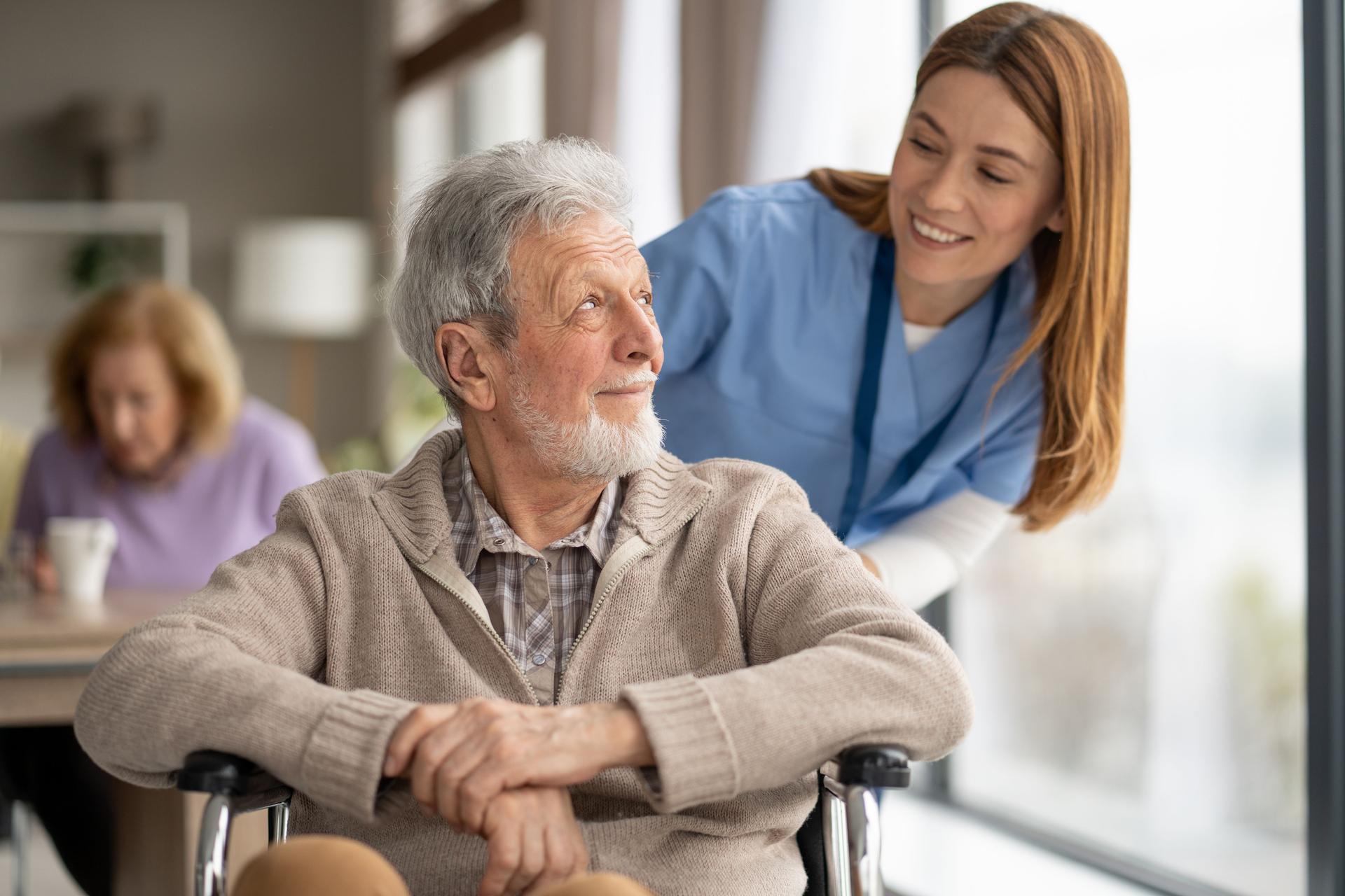 Gentle Exchange Between Caregiver and Senior Man Smiling